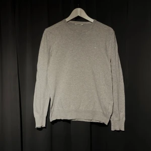 J Lindeberg tröja - En snygg, tunn j.lindeberg tröja i grått. Defekt förekommer på kragen men går att sy ihop!