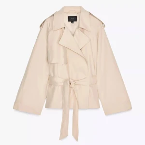 Beige trenchcoat från Zara med bälte - Stilren beige trenchcoat från Zara med klassisk krage, breda slag och knytskärp i midjan. Jackan har långa ärmar och axelklaffar för en trendig look. Perfekt för dig som gillar minimalistisk stil och vill ha en jacka som sticker ut.