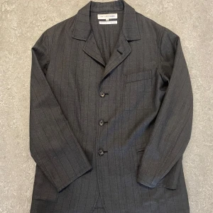 Comme des Garçons Shirt - Kavaj/Blazer - Snygg grå kavaj från Comme des Garçons  Shirt. Notch lapel, fyra knappar och fickor. Tillverkad i 100% ull och gjord i Frankrike. Kan användas både som blazer och jacka. Skriv gärna frågor eller bud! 