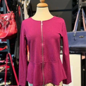 Plommonlila kofta med dragkedja  - Snygg plommonlila kofta från Viveca N med lång ärm och dragkedja framtill. Modellen har lätt utsvängd nederdel som ger en feminin siluett. Tillverkad i mjuk viskosmix med stretch för extra komfort.  ✨ Skick: Mycket bra  ✨ Pris kan diskuteras! ✨Strl: M  💌 Tveka inte att skriva vid frågor eller funderingar