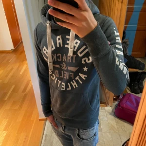 Superdry hoodie - Säljer denna feta hoodien från superdry, skicket är super bra med inga defekter eller så. Modellen är 173. Skriv vid frågor elelr andra funderingar! Priset är ej hugget i sten!