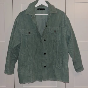 Grön manchesterjacka från Zara XS - Snygg ljusgrön manchesterjacka från Zara i storlek XS. Jackan har klassisk krage, knappar framtill, två bröstfickor med lock och två sidofickor. Oversized passform och rå kant nertill för en chill vibe. Passar personer med storlek L också, beror på vad man vill ha för passform 