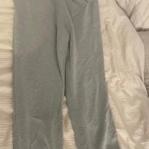 Grå mjukisbyxor från Gina tricot  - Grå mjukisbyxor från gina tricot med resår i midjan och benslut. Tillverkade i mjukt bomullsmaterial som är skönt mot huden. Perfekta för chill dagar eller när du vill ha det extra bekvämt. Klassisk och enkel design utan synliga detaljer.