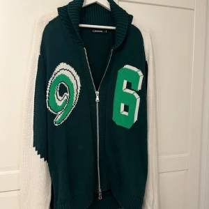 Grön stickad kofta från J.Lindeberg - Riktigt snygg cardigan från J Lindeberg. Snygg grön färg med tryck fram och vita ärmar. En limited Edition modell så går inte att få tag i butik längre. Aldrig använd så helt i nyskick!! Hör av er för fler bilder och frågor!