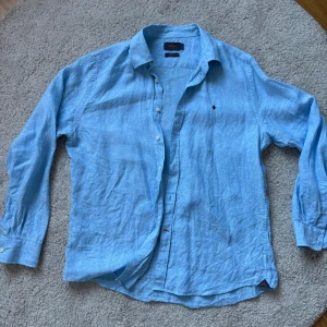 Ljusblå linneskjorta Morris  - Snygg blå skjorta från Morris i 100% linne. Skjortan är inte alls för slim men inte eller för stor på mig. Den är endast använd ett fåtal gånger och är verkligen otroligt bekväm och snygg. Väldigt luftig också