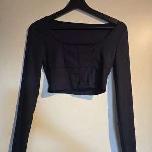 Svart croppad långärmad topp - En svart och en blå, storlek xs. Inget använda men har legat i min garderob. 50kr styck