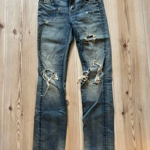 Ripped jeans från Denim & Supply Ralph Lauren - Snygga blå jeans från Denim & Supply Ralph Lauren med slitna och trasiga detaljer på benen och bakfickorna. Modellen har klassisk femficksdesign, låg midja och raka ben. Materialet är bomull med lite stretch för skön passform.