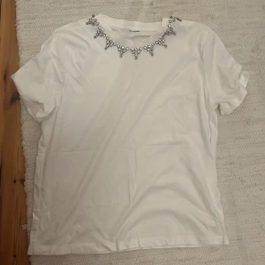 Fin T-shirt med detaljer  - Fin tahirt med ”diamant” detaljer. Storlek och Märke är oklart. Skulle säga att storleken är S/M. Skicket är jättefint 