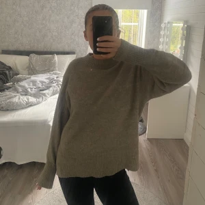 Beige stickad tröja från H&M - Mysig beige stickad tröja från H&M i oversized modell. Tröjan har rund halsringning, breda ribbade muddar vid ärmslut och nederkant samt långa ärmar. Perfekt för lager-på-lager under kyliga dagar.