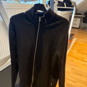 Svart stickad kofta från Only & Sons - Svart stickad kofta från Only & Sons med hel dragkedja och hög krage. Perfekt för lager-på-lager och enkel att matcha med andra plagg. Långärmad och i klassisk, stilren design som funkar året runt. Som sprillans ny passar både för M och S