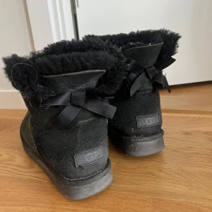 Svarta Uggs rosett - Jättefina skor från UGG som är använda under en period men fortfarande i fint skick o har mycket kvar att ge 🩷