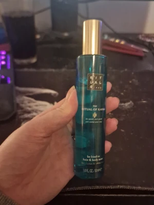 Rituals The Ritual of Karma mist - Fräsch hår- och kroppsmist från Rituals i serien The Ritual of Karma. Flaskan är turkosblå med guldfärgat lock och rymmer 50 ml. Doften är inspirerad av helig lotus och vit te, perfekt för dig som vill ha en lätt och upplyftande parfym.