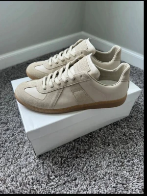 Sneakers Mason margiela GAT Oliver cabell - Snygga beige sneakers med ovandel i mocka och skinn, klassisk design och gummisula. Skorna har snörning och en låg siluett som passar till många olika stilar. Perfekta för dig som gillar stilrena och neutrala färger. Produkten skickas dagen produkten blir beställd eller dagen där på, priset kan gå ner.  