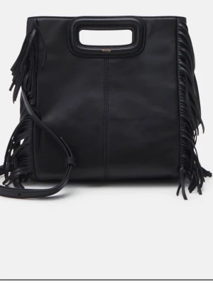 Svart axelväska med fransar från Maje -  Säljer en svart axelväska från Maje i skinn med coola fransar på sidorna och ett stilrent handtag upptill. Maje märket är rätt slitet och syns inte super mycket längre eftersom jag använt väskan Väldigt mycket under sommaren! Men lädret är fof fint det är mest handtaget som blivit rätt slitet!  Väskan har en avtagbar axelrem och minimalistisk design som ändå sticker ut. Perfekt för dig som gillar en edgy look.