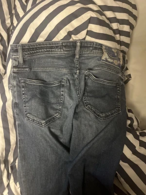 Blå jeans från Jacob Cohen, stl 30 - Snygga blå jeans från Jacob Cohen med klassisk femficksdesign och tydliga sömmar. Jeansen har en patch med logga bak i midjan och är tillverkade i mjukt denimtyg. Perfekta för dig som gillar stilrena och tidlösa jeans.Tar byten och kan gå ner i pris vid snabbt köp