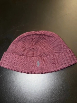 Vinröd mössa från Ralph lauren - Säljer en vinröd Ralph lauren mössa som är i väldigt bra skick då jag bara har användt den ett fåtal ggr. Köpte mössan för 649 kr! PRISET GÅR ATT DISKUTERAS!!!