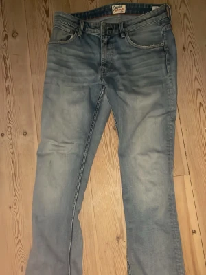 Ljusblå bootcut jeans - W 31 L 32 Snygga ljusblå jeans med bootcut passform och klassisk femficksdesign. Jeansen har en något utsvängd benslut och är tillverkade i mjukt denimtyg. Perfekta för en avslappnad och trendig look.