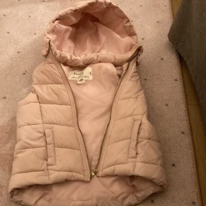 Ljusrosa dunväst med huva från H&M 💗 - Säljer en ljusrosa dunväst från Handsome med quiltad design och stor huva. Västen har dragkedja framtill och är lätt vadderad för extra värme. Perfekt för lager på lager och en snygg detalj till din outfit. Har ett medelstort hål på insidan av västen men det ser man inte och det blir liksom inte kallare eller nåt av hålet. På namnlappen så har jag skrivit mitt namn sen tidigare men det går superlätt att täcka av sin egen namnlapp! ☺️