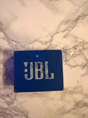 Blå JBL bärbar högtalare -  PRIS KAN DISKUTERAS!!!! Snygg blå bärbar högtalare från JBL i kompakt, fyrkantig design. Jätte bra ljud inte så högt som stora högtalare men ändå så skakar borden när det är på Max volym ser använd ut men det är så himla bra behöver den inte därför säljer jag den kan också skicka video när jag spelar upp en låt högt ljud 