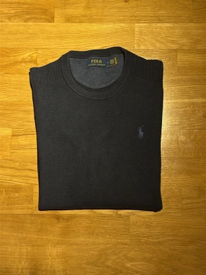 Mörkgrå stickad tröja Polo Ralph Lauren - Säljer en mörkgrå stickad tröja från Polo Ralph Lauren i storlek M. Tröjan har rund halsringning, ribbade muddar och diskret broderad logga på bröstet. Bra skick, nypris 2295kr och äkta med QR kod. Hör av dig vid frågor eller prisförslag…