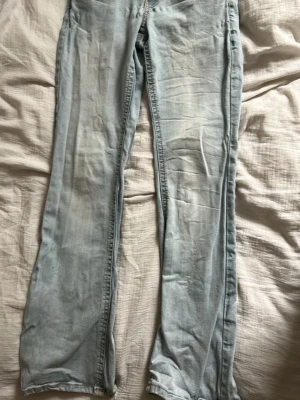Ljusblå jeans från Ginatricot - Säljer ett par ljusblå jeans från Perfect Jeans i storlek 36. Klassisk femficksmodell med dragkedja och knapp framtill. Jeansen har raka ben och är sydda i mjukt denimtyg med kontrastsömmar. Perfekta till en avslappnad look.