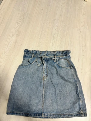 Blå jeanskjol med knyt H&M - Kjolen har knytband i midjan och klassiska fickor både fram och bak. 