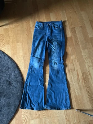 Blå bootcut jeans från Bubbleroom - Säljer ett par blå jeans från Bubbleroom i storlek 38. De har klassisk femficksdesign, normal midja och riktigt snygg bootcut passform som ger en retrovibe. Materialet är klassiskt jeans med lite stretch för extra komfort.