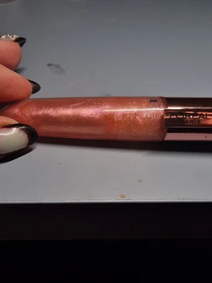 L'Oréal Paris skimrande läppglans lipp plumper - Säljer ett läppglans från L'Oréal Paris i en persikofärgad ton med massor av skimmer och glittereffekt. Kommer i en snygg tub med roséguldfärgat lock och har en mjuk applikator för enkel applicering. Perfekt för dig som vill ha glansiga och fylliga läppar.