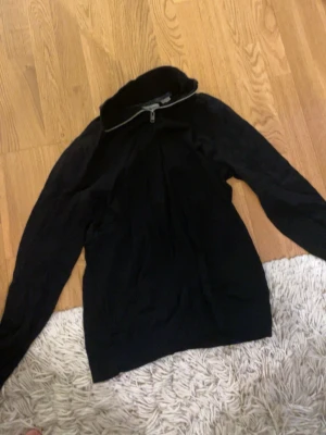 Svart halvzip stickad tröja - Mysig svart stickad tröja med halv dragkedja i halsen. Perfekt för kyliga dagar och enkel att matcha med allt. Långärmad och med hög krage som går att vika ner. Har fler varor, bara att kolla i min profil.