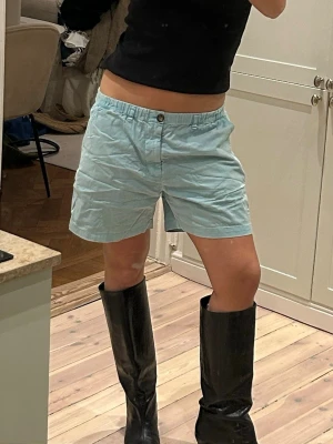 Ljusblå shorts från Chubbies - Säljer ett par ljusblå shorts från Chubbies med relaxed fit och elastisk midja. Shortsen har sidofickor, en bakficka med knapp och stängs med knapp och gylf framtill. Perfekta för sommardagar och chill häng.
