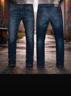 Nudie Jeans blå jeans, W31 L31 - Säljer ett par klassiska blå jeans från Nudie Jeans i modellen 'Grim Tim'. Jeansen är tillverkade i 100% ekologisk bomull och har en snygg straight fit med orange sömmar och läderpatch bak. Perfekta för dig som gillar stilrena och tidlösa jeans.