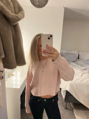 Ljusrosa croppad stickad tröja - Superfin ljusrosa croppad stickad tröja med ribbad struktur och långa ärmar. Perfekt till jeans eller kjol för en chill och snygg look. Tröjan har en loose passform och är riktigt mjuk och skön.