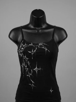 Svart linnetopp tribal  - Säljer en svart linnetopp med tunna axelband och ett coolt vitt tribal på framsidan. Toppen har en figurnära passform och är perfekt för dig som gillar en edgy och trendig stil. Materialet känns mjukt och följsamt.