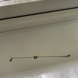 Armband med fjäril i silver - Sött och tunt armband i silverfärg med en liten fjäril. Perfekt accessoar för dig som gillar detaljer och vill ha något unikt på handleden.