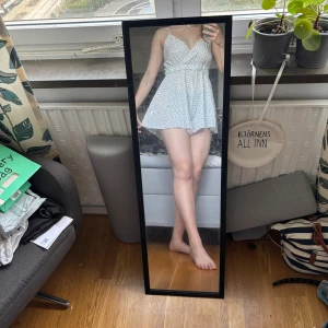 Vit hjärtprickig kort playsuit - Supersöt vit kort playsuit från Shein med svarta hjärtan som mönster. Klänningen har smala axelband, v-ringning och markerad midja. Perfekt för varma dagar och ger en lätt och luftig känsla. Materialet är tunt och mjukt, polyester. Aldrig använd så är som ny. Pris går att diskutera.