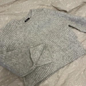 Stickad tröja - Grå stickad tröja med slits nere vid ärmarna och vid midjan. Från Gina tricot använd fåtal gånger 