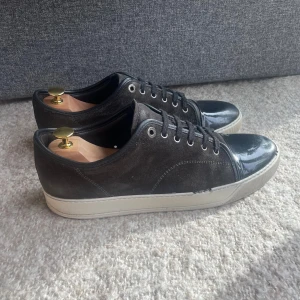 Lanvin skor - Hej, säljer nu dessa Lanvin skor. Bra glans och en unik färg. Garanterad äkthet. Storlek 10 vilket motsvarar 44. Undersulan på skon är i mycket bra skick vilket visas i annonsen. Dessvärre tappat små delar runtom skon men de går att laga. Hör av dig vid eventuella frågor!