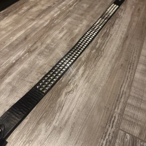 Svart nitarbälte i skinn!! - Säljer ett svart bälte i skinn med silvriga fyrkantiga nitar längs hela bandet. Bältet har en klassisk metallspänne och en bredare design som ger en edgy vibe. Perfekt accessoar för att lyfta din outfit med lite extra attityd 🥰🥰