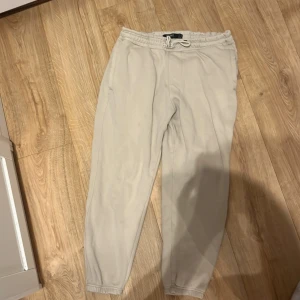 Beige mjukisbyxor från Pull&Bear L - Beiga mjukisbyxor från Pull&Bear i storlek L. Byxorna har resår och snörning i midjan, elastiska benslut och fickor både fram och bak. Sköna och stilrena, perfekta för chill dagar eller när du vill vara bekväm.