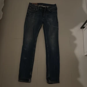 Acne Studios Blå Konst jeans blå 29/30 - Snygga blå jeans från Acne Studios Blå Konst med klassisk femficksdesign och diskret slitning. Modellen har raka ben och normal passform. Jeansen är tillverkade i bomull och har en cool tvättad look.