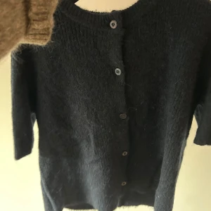 Svart stickad kofta från Gina Tricot - Mysig mörkblå stickad kofta från Gina Tricot med rund halsringning och knappar framtill. Från barnavdelningen men passar mig som har storlek S. 