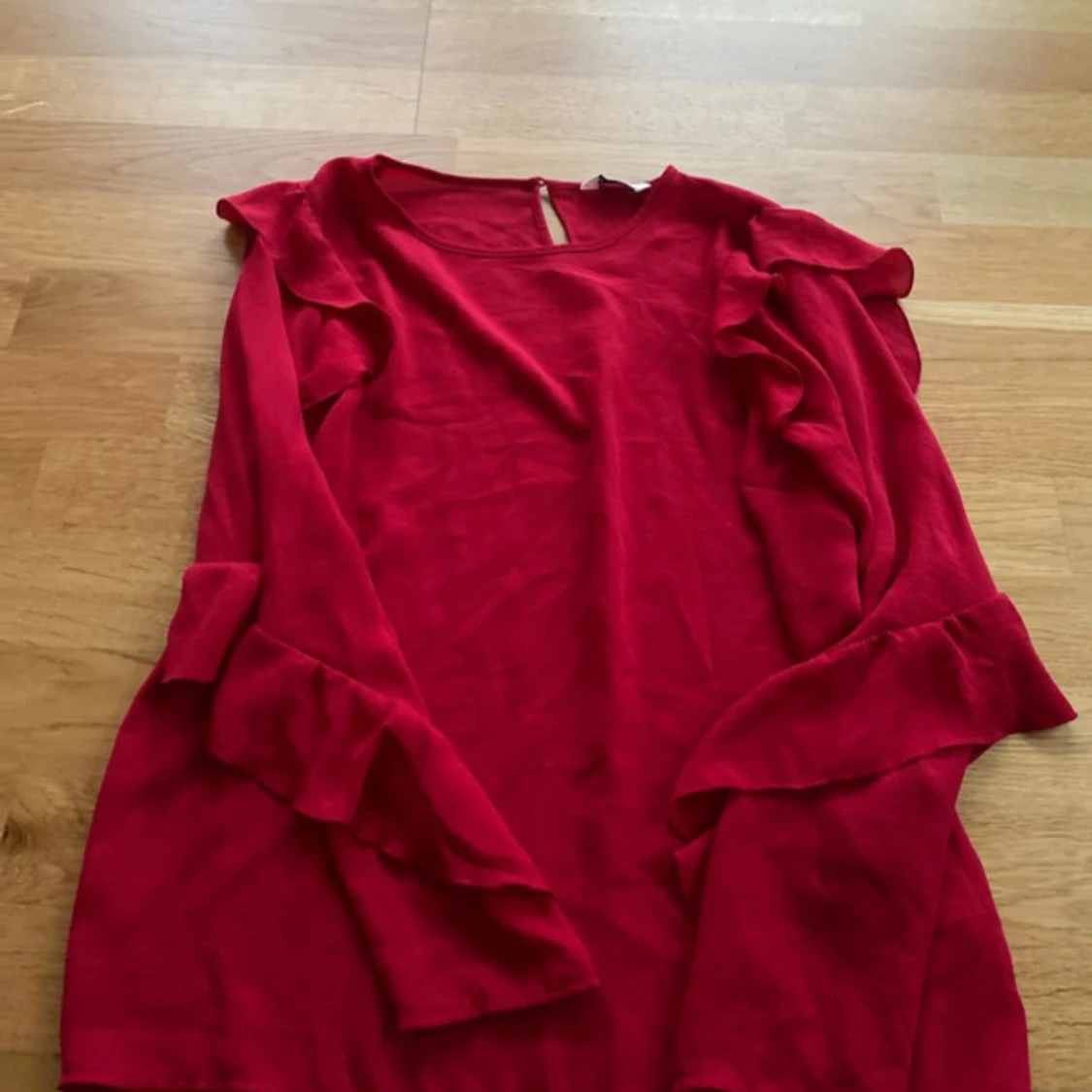 Röd blus med volangdetaljer