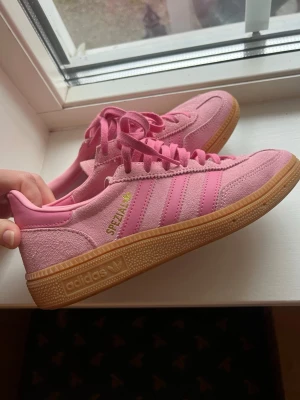 Adidas Spezial rosa sneakers - Säljer ett par Adidas Spezial som är rosa med beige/brun gummisula. Skorna har ovandel i mocka och detaljer i skinn, samt snörning framtill. Säljer för att de inte använts så mycket. Kan gå ner i pris så skriv om ni har ett annat prisförslag😊😊