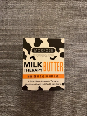 Morfose Milk Therapy Butter - Morfose Milk Therapy Butter är en hårvårdsprodukt med jojoba, shea, avokado, tamanu och kokosolja. Förpackningen är svartvit med orange detaljer och har ett coolt ko-mönster. Perfekt för dig som vill ge håret extra näring och glans.