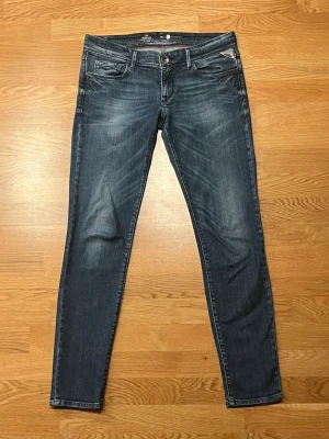 Replay jeans - Snygga mörkblå jeans från Replay i skinny fit med klassisk femficksdesign och diskreta slitningar. Jeansen har normal midja och är tillverkade i stretchigt denim för en bekväm passform. Perfekta för dig som gillar en smal siluett och stilren look.