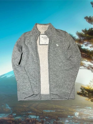 Abercrombie & fitch fleece - Riktigt snygg Abercrombie & Fitch zip fleece med fordring på insidan, storleken är M och samma med passformen. Den är i ett mycket bra skick förutom lite blått ludd som fastnat från andra kläder på fordringen på insidan, finns att se på bilderna.