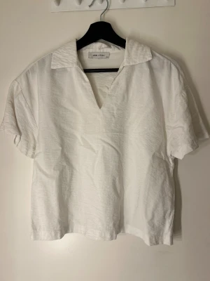 Vit henley från LCW Vision, strl 34 - Klassisk vit henley från LCW Vision i storlek 34. Skjortan har korta ärmar, mjukt bomullstyg och en öppen krage med v-ringad hals. Enkel och clean design som passar till allt. Perfekt för dig som gillar minimalistisk stil.