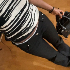 Victoria Beckham bootcut jeans - Svarta jeans från Victoria Beckham med bootcut passform och låg midja. Snygga detaljer med vita sömmar och lila patch bak. Jag år 161 och dom passar perfekt!!