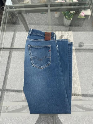 Replay Grover jeans W32 L32 – straight fit - Säljer mina Replay Grover jeans i storlek W32 L32. De sitter riktigt bra med sin straight fit och klassiska blå tvätt. Snygga detaljer på bakfickorna och lagom slitage framtill som ger en stilren men avslappnad look.  Jeansen är i mycket bra skick – inga hål, fläckar eller konstigheter. Modellen Grover är perfekt om du vill ha ett par bekväma, raka jeans som funkar till allt.  Storlek: W32 / L32 Passform: Straight fit Skick: Mycket bra Märke: Replay (modell Grover)  Nypris ca 1400–1600 kr. 