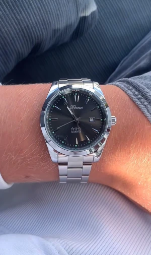 Silverfärgad Doventi klocka med svart urtavla - Stilren klocka från Donell med svart urtavla, datumvisning och silverfärgat armband i rostfritt stål. Klassisk rund form med tydliga indexmarkeringar och kvartsverk. Perfekt accessoar för dig som gillar en clean och tidlös look.